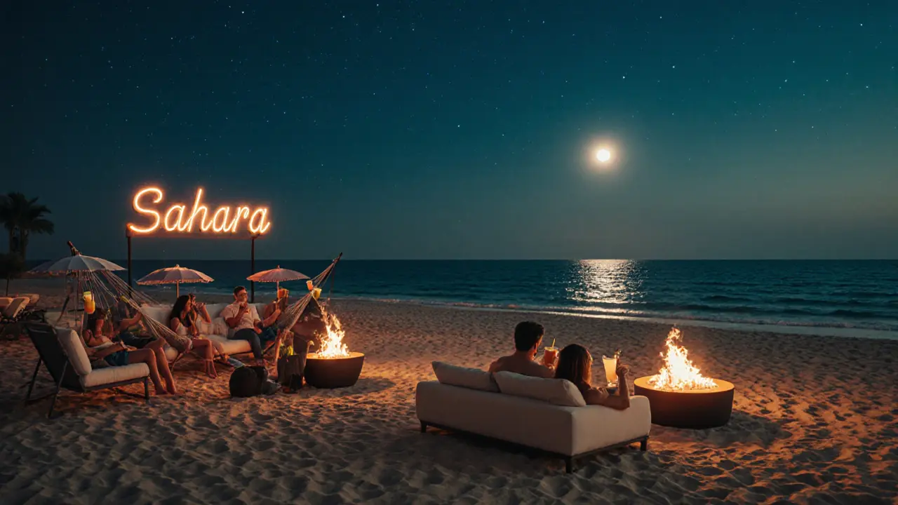 Moonlit beach lounge at Sahara Beach Club with fire pits and cocktails.