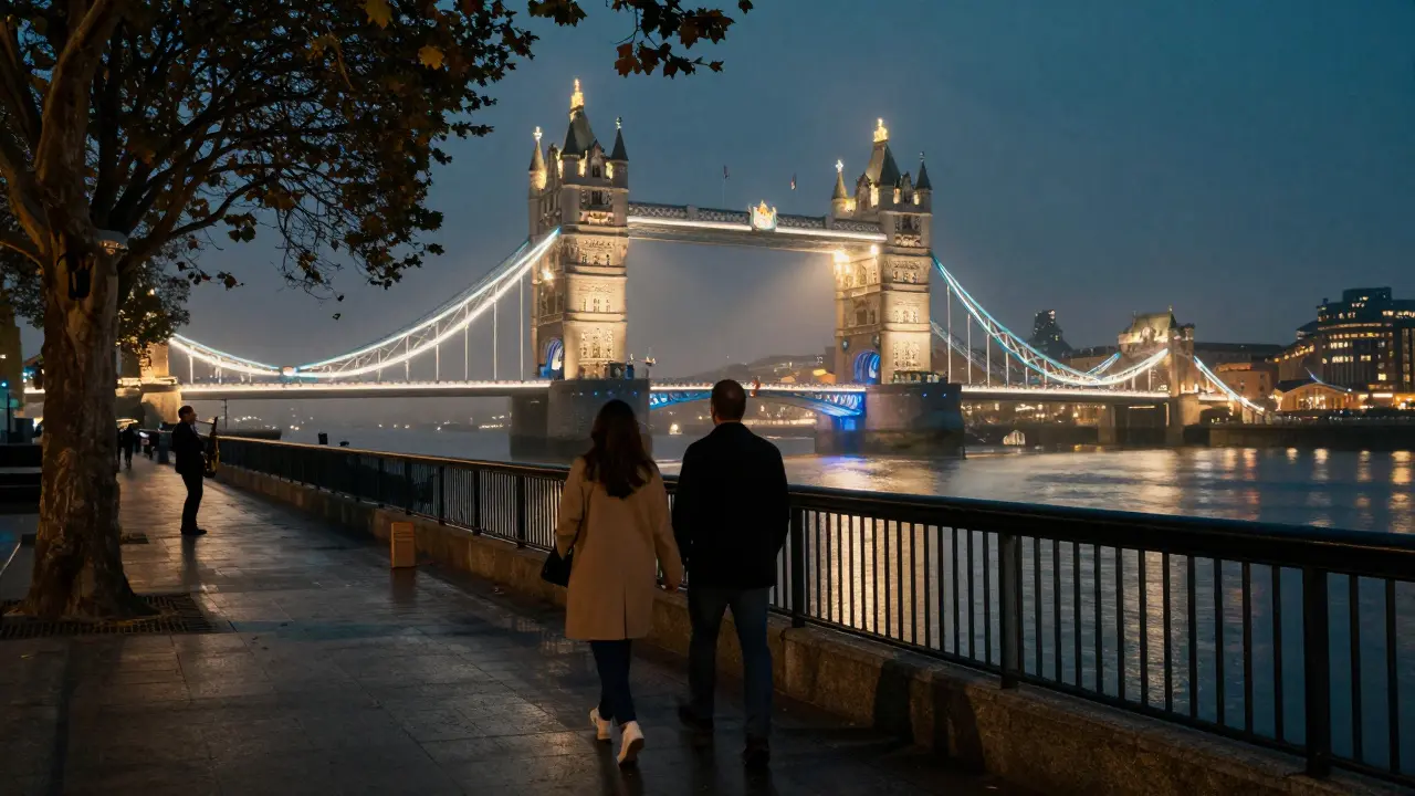 A couple walking hand in hand along the Thames at night, bridges glowing above reflective water.