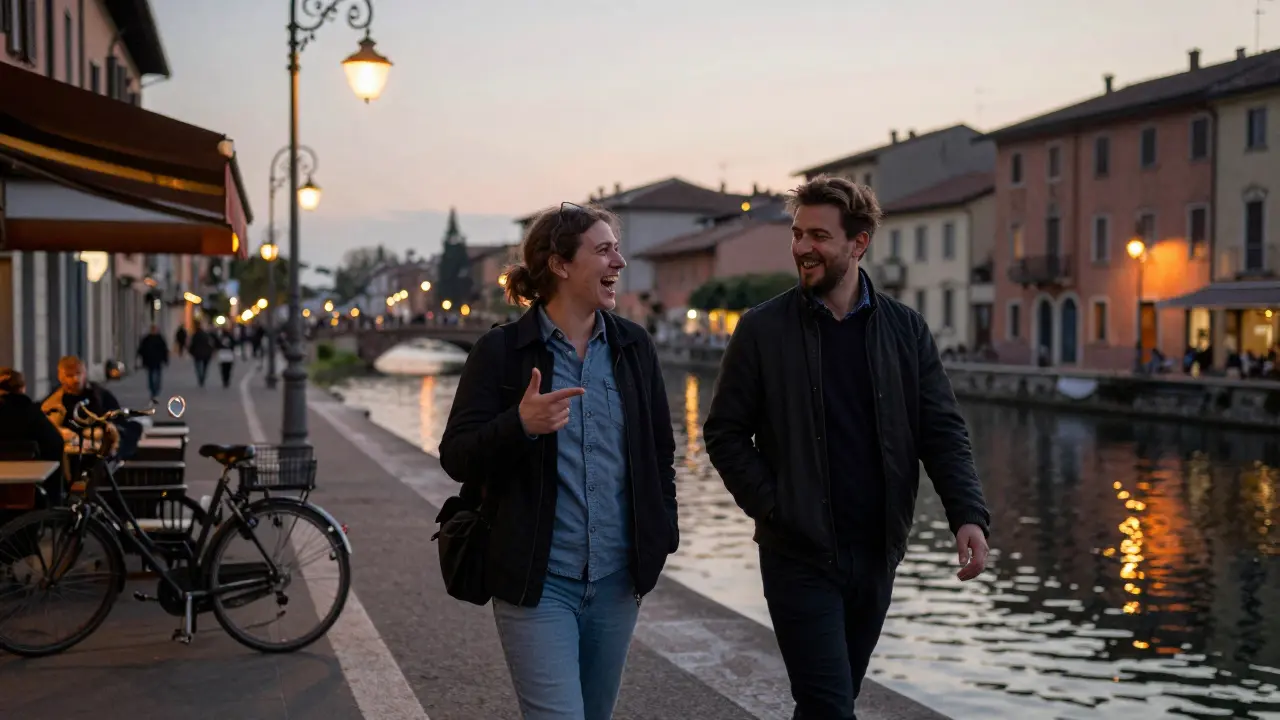 Two people walking along Navigli canal at dusk, laughing and talking under glowing lanterns.